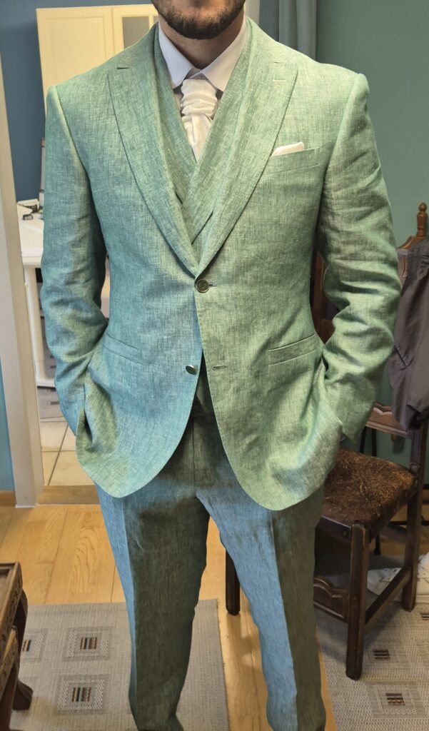 couple de mariés en robe longue blanche et costume vert foncé